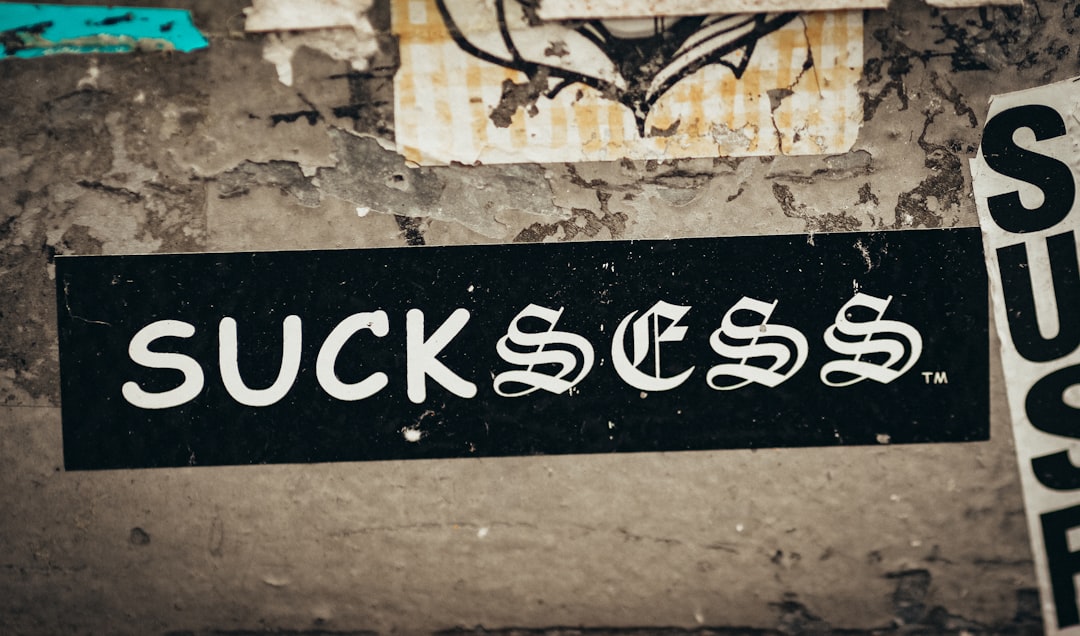 a-black-and-white-street-sign-on-a-wall-syqkrv5smre